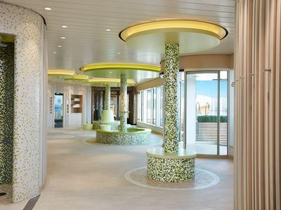 Moderner Hotelbereich mit runden Sitzgelegenheiten und verzierten Säulen, helle und offene Atmosphäre.