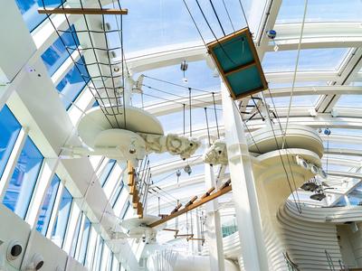 Helle Indoor-Wasserrutsche in einem modernen Gebäude mit Glasdach und blauen Fenstern.