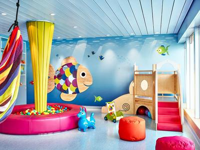 Buntes Kinderzimmer mit Bällebad, Rutsche und lebendiger Fischwanddekoration.