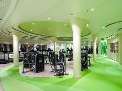 Moderner Fitnessraum mit Cardio- und Kraftgeräten, grünem und weißem Farbdesign