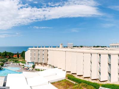 Bagno moderno con piastrelle grigie, doccia, WC e lavabo.