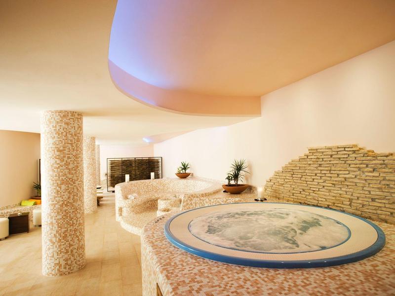 Helle Hotelhalle mit rundem Empfangstresen und stilvollen Säulen.