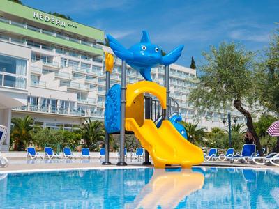 Bunter Wasserrutschen-Spielbereich am Hotelpool bei sonnigem Wetter.