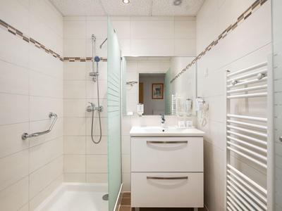 Modernes weißes Badezimmer mit Dusche und Waschbeckenunterschrank