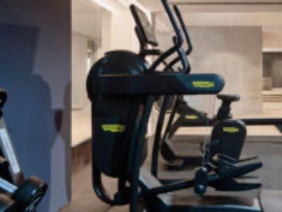 Modern exercise machines in a bright, spacious hotel gym.