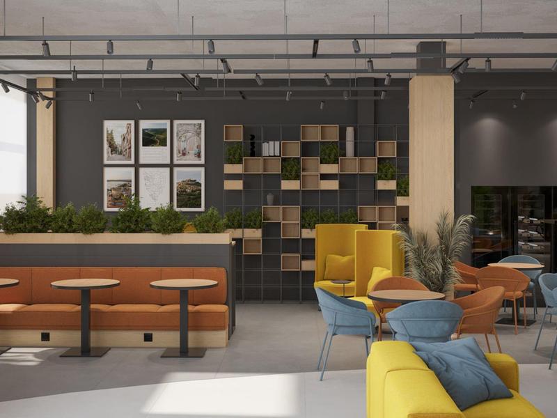 Moderní hotelová lounge s barevným sezením a knihovnou na stěně.