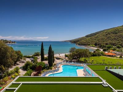 Blick auf einen Pool vor einer Uferlandschaft mit Hügeln und blauem Himmel.