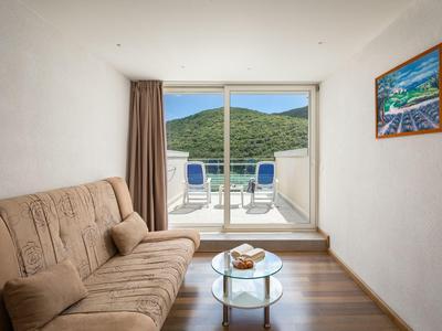 Acogedora sala con vista a la terraza y colinas verdes a través de grandes ventanas