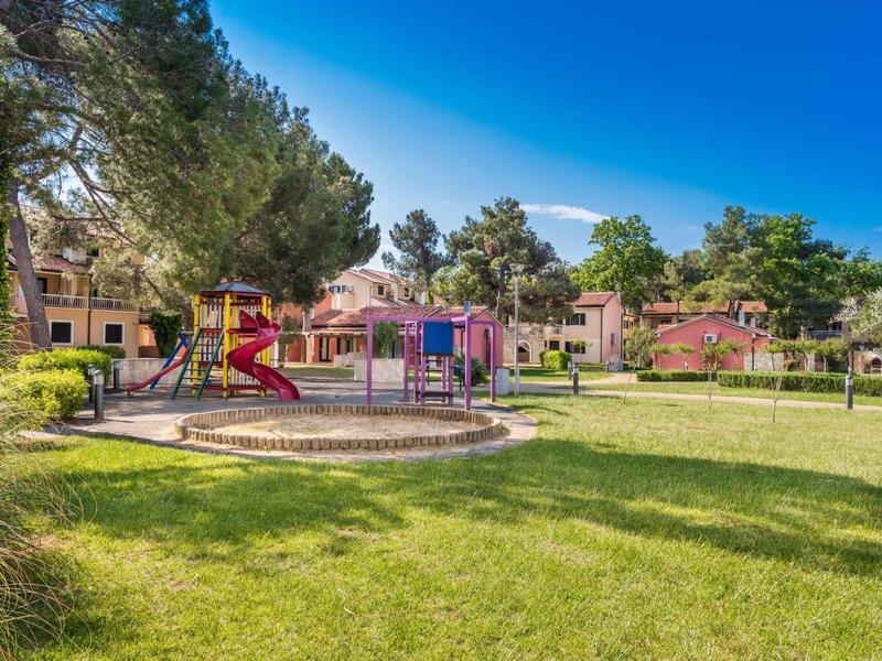 Children's playground with slide in a hotel park on a sunny day.
