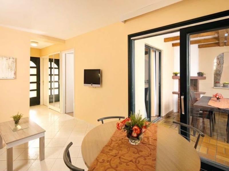 Bright living and dining room with glass door to terrace and modern furnishings.