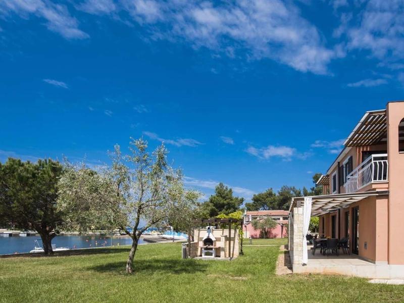 Hotel building with green lawn and sea view under blue sky