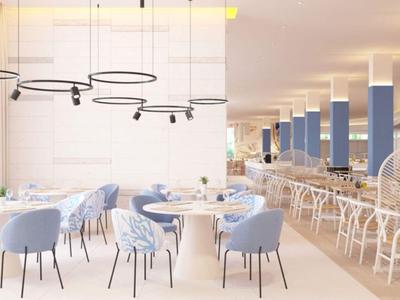 Licht, modern restaurant met blauwe stoelen en witte tafels, versierd met moderne hanglampen.