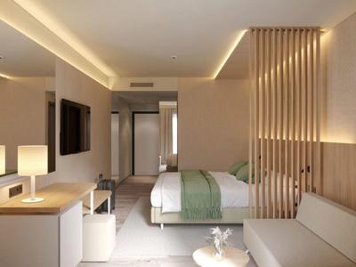 Habitación de hotel moderna con cama doble, sofá y luz indirecta.