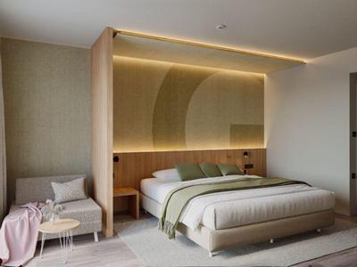 Dormitorio moderno con cama grande, zona de estar e iluminación indirecta sobre el cabecero.