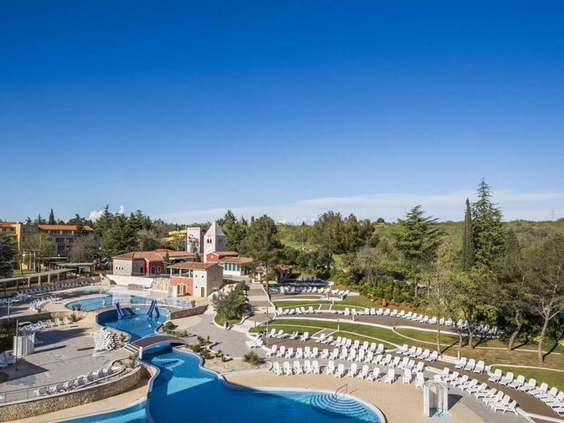 Vista de una gran piscina al aire libre con tumbonas en un día soleado en un resort hotelero.