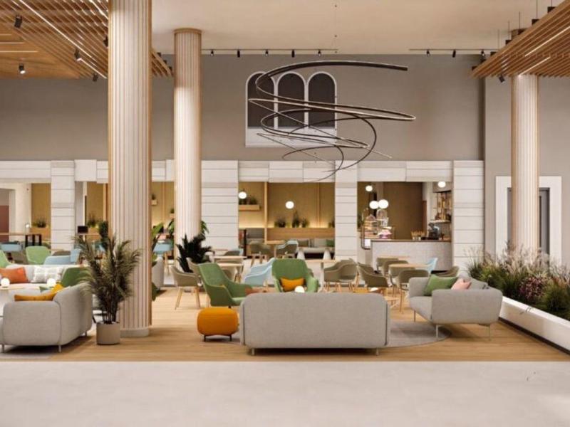 Área luminosa del vestíbulo del hotel con sofás cómodos y detalles modernos.