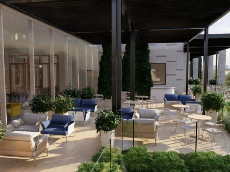 Área exterior moderna con sillas cómodas y plantas verdes bajo una cubierta