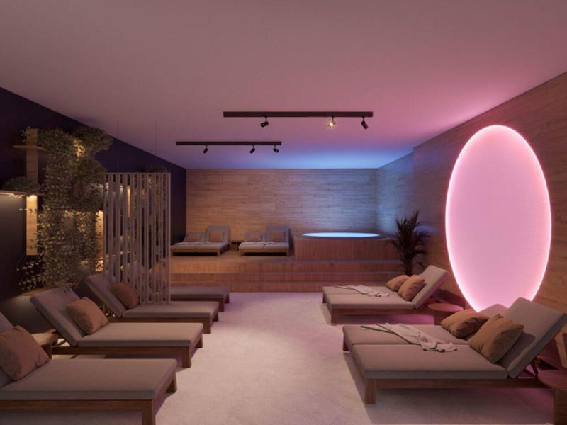 Sala de relajación de spa moderna con cómodas tumbonas y iluminación ambiental LED.