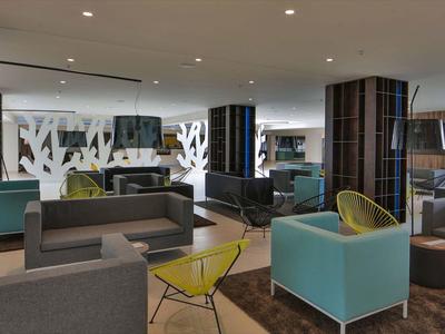 Moderní hotelová lobby s pohodlnými křesly a pohovkami v různých barvách.