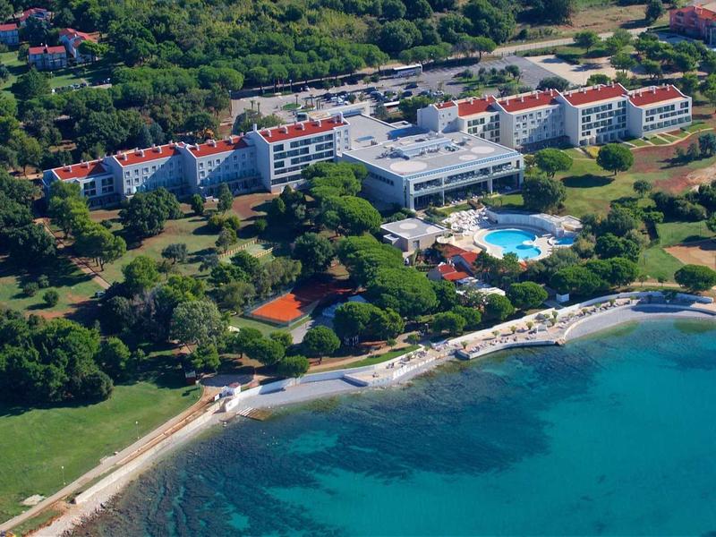 Ośrodek hotelowy nad morzem z basenem, otoczony drzewami i plażą