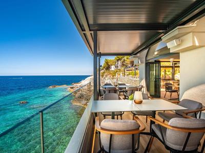 Nowoczesna restauracja nad morzem z miejscem do siedzenia i widokiem na czystą, błękitną wodę