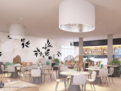 Modern hotelrestaurant met witte stoelen, groene fauteuils en lichte houten inrichting.