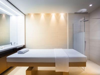 Minimalistischer Wellnessraum mit Massagebank, klaren Linien und warmem Licht.