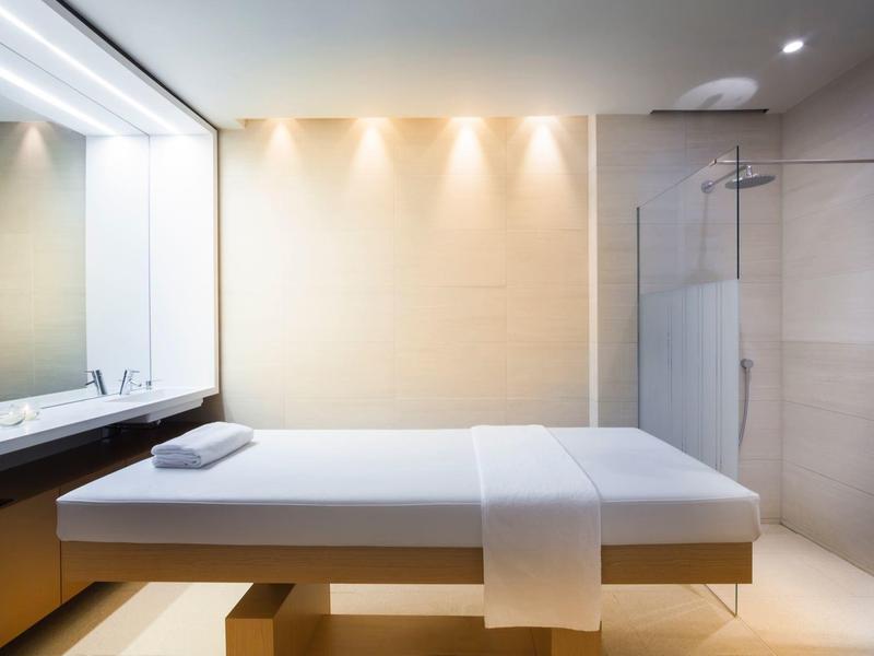 Minimalistischer Wellnessraum mit Massagebank, klaren Linien und warmem Licht.