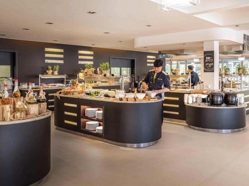 Lobby dell'hotel moderna con eleganti banchi vendita rotondi e illuminazione decorativa.