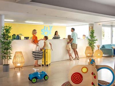 Hotelreceptie met gasten en bagage, helder en modern ingericht.