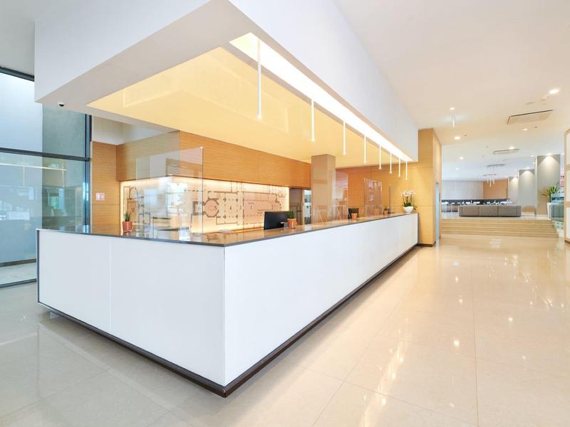 Modern bright reception desk in a clean, minimalist hotel setting.