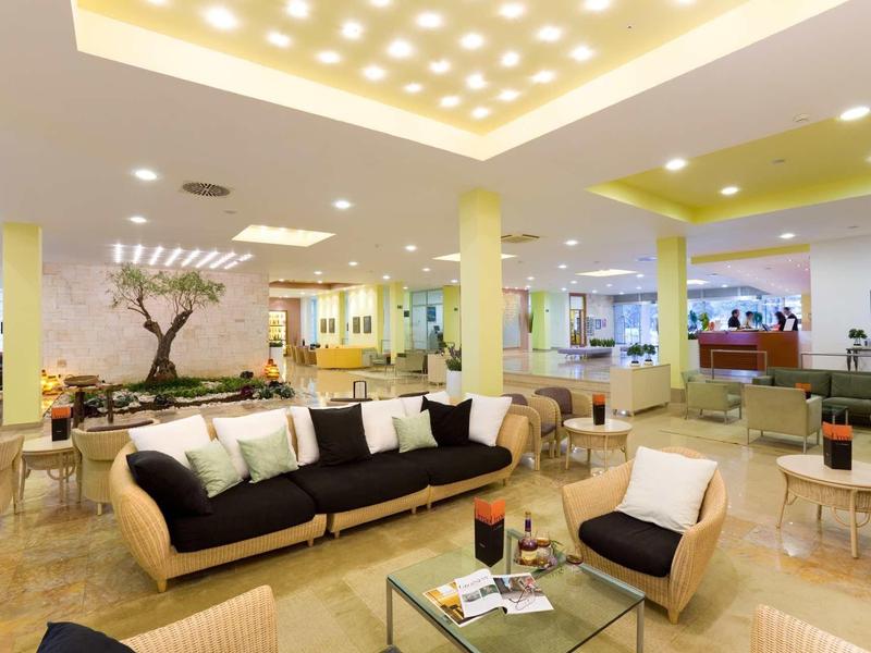 Salon d'hôtel lumineux et moderne avec canapés confortables, fauteuils et design contemporain.