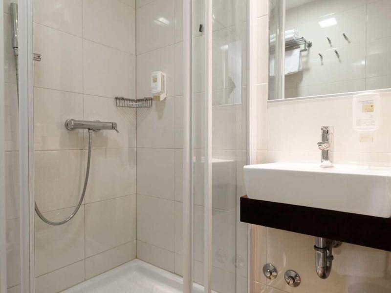 Moderne badkamer met ronde douche en grote spiegels