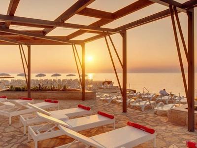 Coucher de soleil sur la plage avec transats et structure de tonnelle en bois