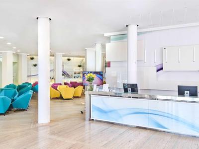 Réception d'hôtel lumineuse avec comptoir moderne et sièges colorés dans la salle d'attente.