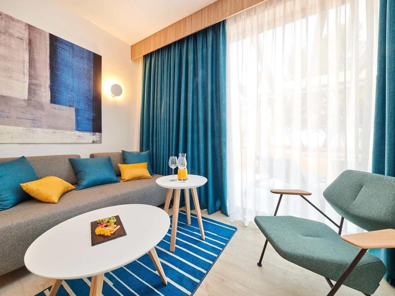 Soggiorno moderno con accenti blu e gialli, tavolino e luce naturale