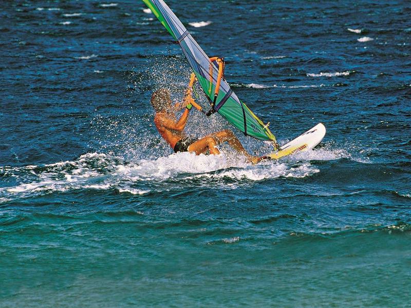 Personne faisant de la planche à voile sur la mer entourée d'eau et de vagues.