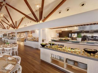 Groot restaurant met buffet, houten balkenplafond en gevulde voedselbalies.