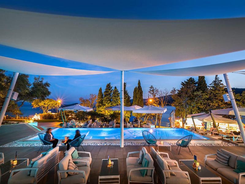 Modern hotel outdoor area with heated pool and cozy seating at dusk.