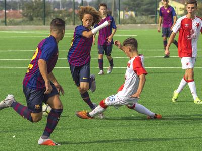 Giocatori di calcio si sfidano su un campo verde durante una partita.