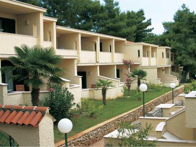 Rijhuizen met balkons in een groene, goed onderhouden omgeving met lantaarnpalen.