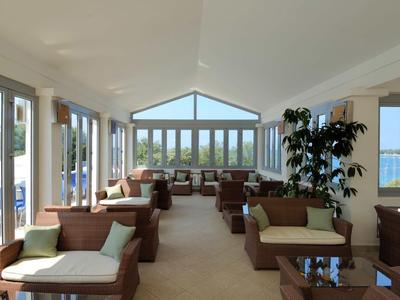 Heller Hotel-Loungebereich mit Sofas, großen Fenstern und Blick auf die Natur.