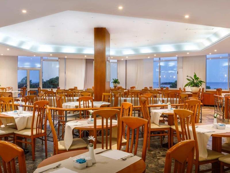 Sala da pranzo spaziosa e elegante con mobili in legno e finestre panoramiche alla luce del giorno.