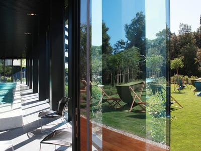 Nowoczesne wnętrze z krzesłami i widokiem na słoneczny ogród z miejscami do siedzenia.