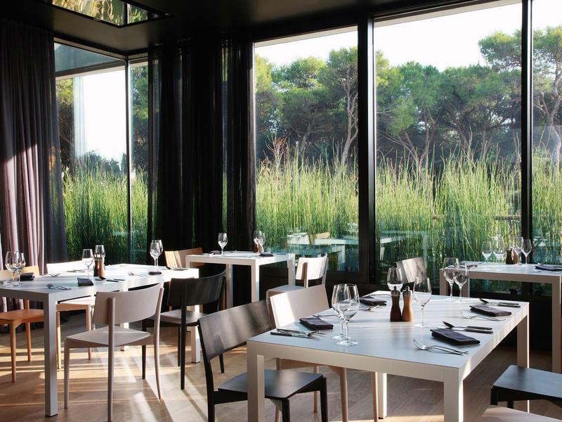 Nowoczesna restauracja z dużymi oknami z widokiem na zieloną przestrzeń na zewnątrz