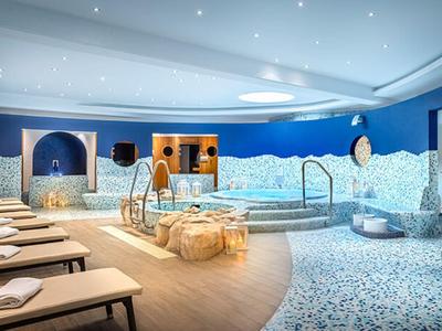 Moderní wellness s vířivkou, lehátky a relaxační atmosférou.