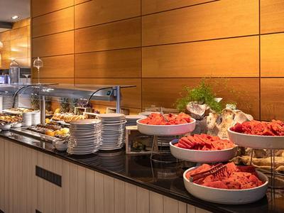 Buffet avec divers plats et assiettes dans un restaurant d'hôtel moderne.