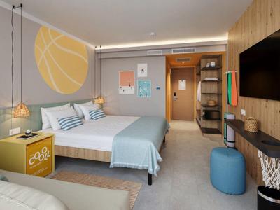 Chambre d'hôtel moderne avec lit double, art mural lumineux, TV et coin salon.