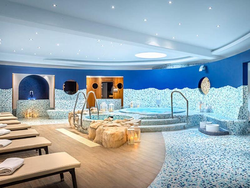 Espace bien-être moderne avec piscine, chaises longues et ambiance détendue.