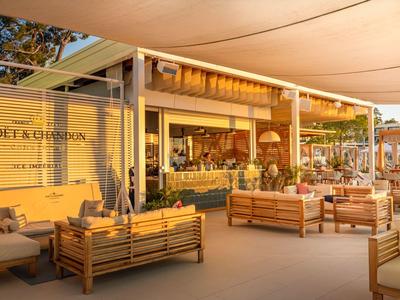Sunlit lounge with wooden furniture and cozy terrace at sunset.